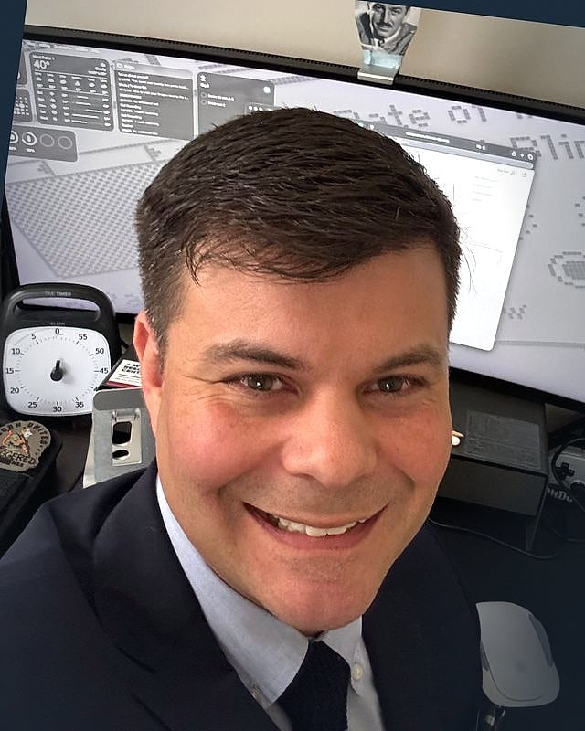 Bart Eskind, in suit and tie, at his desk in Clermont, Florida